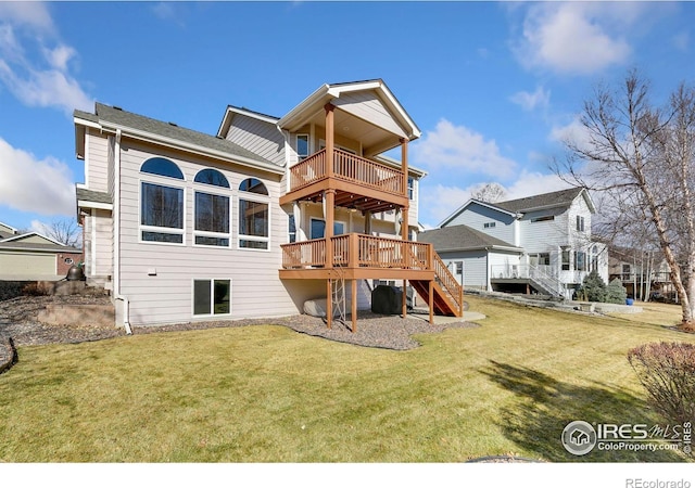 rear view of property featuring stairs, a lawn, a wooden deck, and a balcony