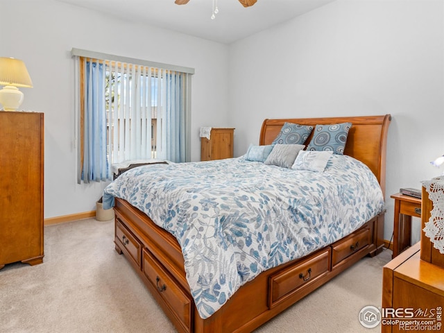 bedroom featuring a ceiling fan, light colored carpet, and baseboards