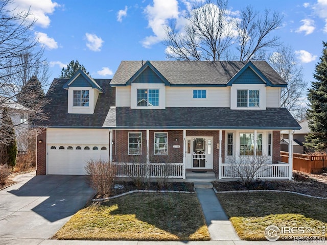 view of front of house featuring a porch, brick siding, driveway, and a front lawn