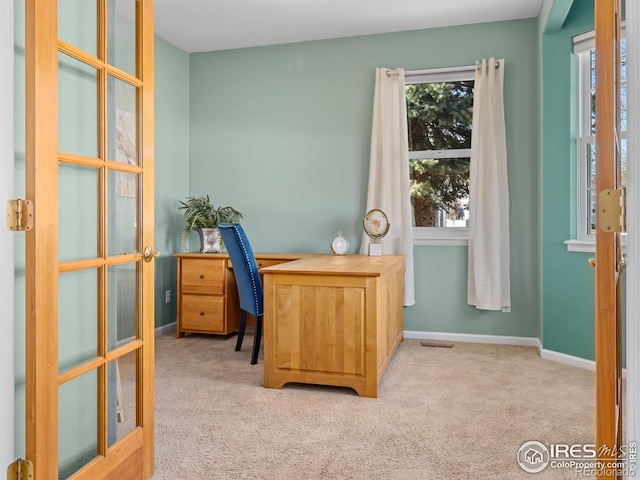 carpeted office space featuring visible vents and baseboards