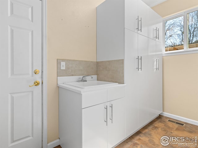 bathroom with vanity, visible vents, and baseboards