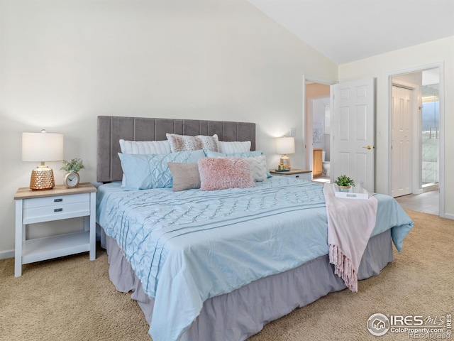 bedroom with carpet, lofted ceiling, and ensuite bath