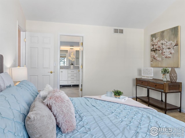 bedroom featuring ensuite bath, visible vents, and baseboards