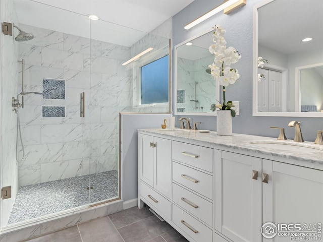 full bathroom with double vanity, a sink, a marble finish shower, and recessed lighting