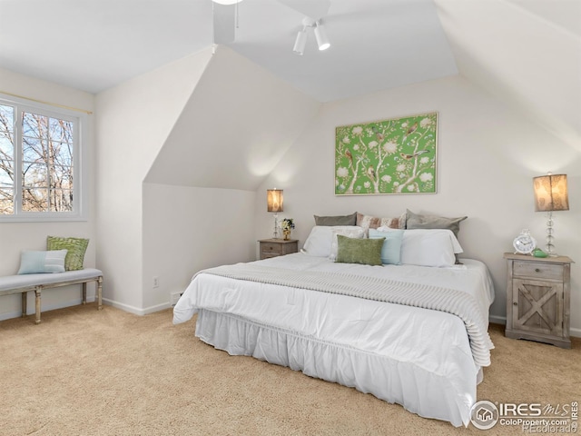 carpeted bedroom with a ceiling fan, vaulted ceiling, and baseboards