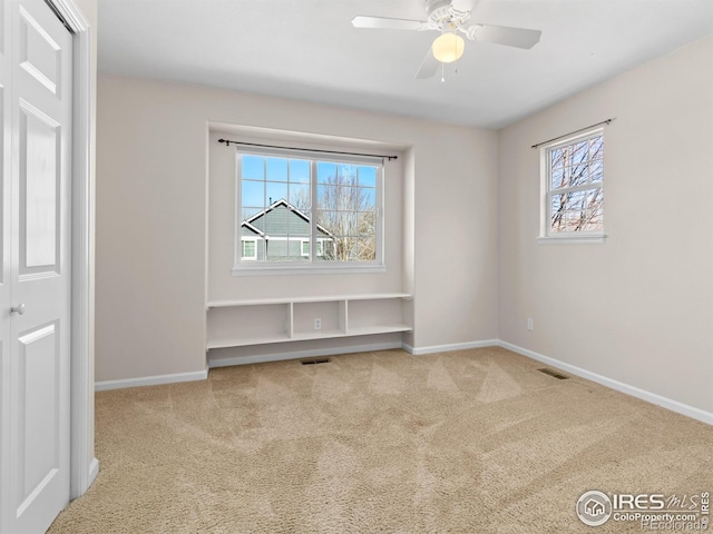 unfurnished bedroom with carpet, visible vents, and baseboards