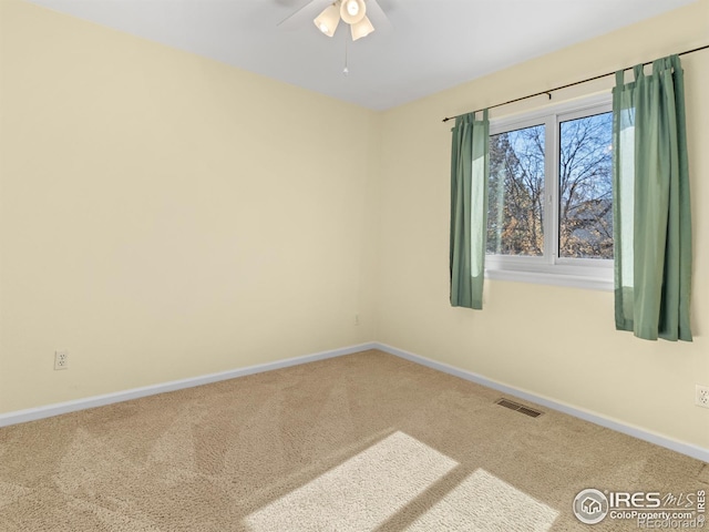 empty room featuring carpet floors, visible vents, and baseboards