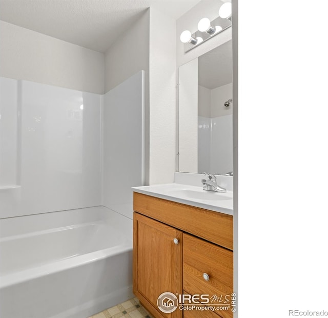 bathroom featuring tile patterned floors, shower / washtub combination, and vanity