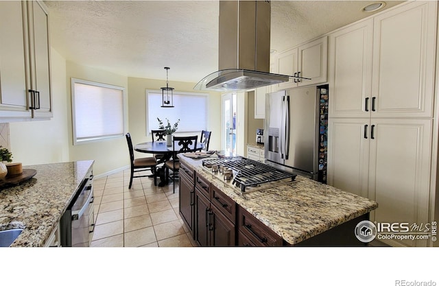 kitchen featuring stainless steel appliances, light stone countertops, a textured ceiling, and island range hood