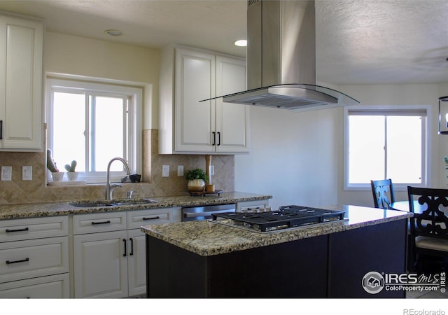 kitchen with white cabinetry, appliances with stainless steel finishes, island exhaust hood, and a sink