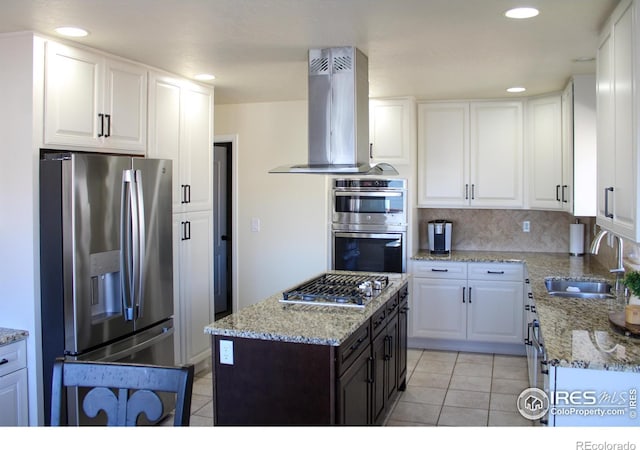 kitchen featuring light tile patterned floors, a sink, stainless steel appliances, white cabinetry, and island range hood