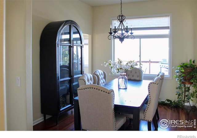 dining room with dark wood finished floors and a notable chandelier