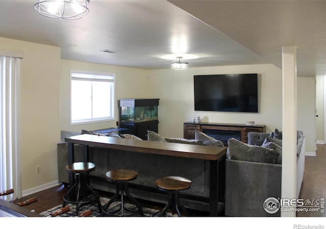 living room featuring visible vents, baseboards, and dark wood-type flooring