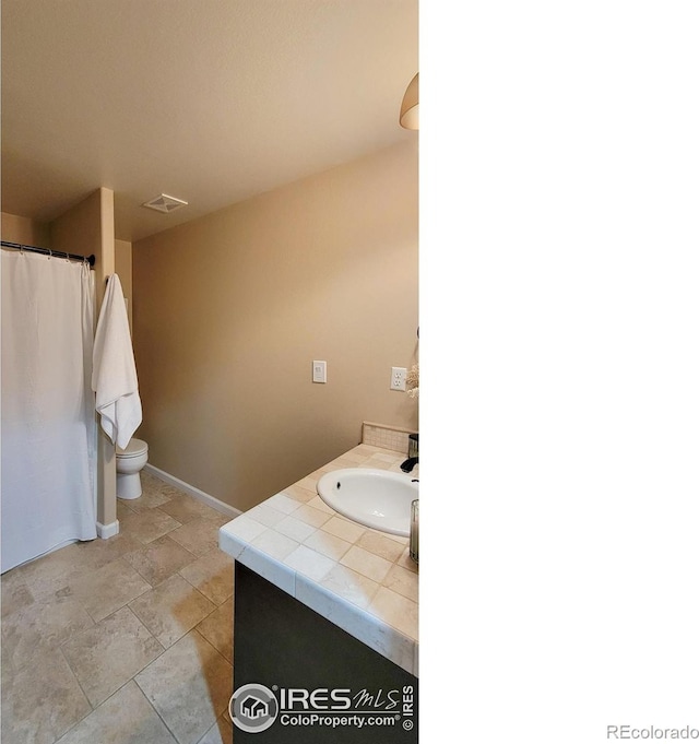 bathroom featuring vanity, toilet, and visible vents