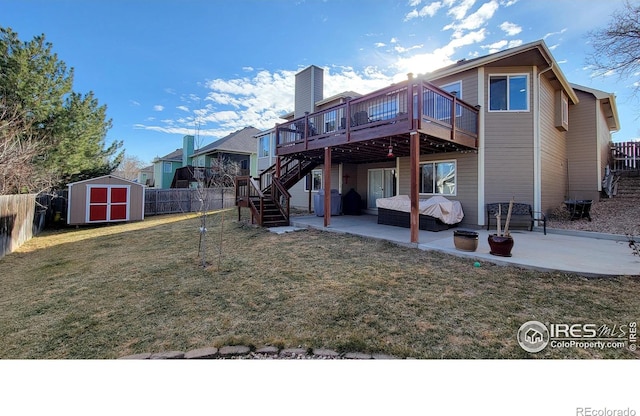 rear view of house featuring a patio, stairway, a storage unit, and an outbuilding