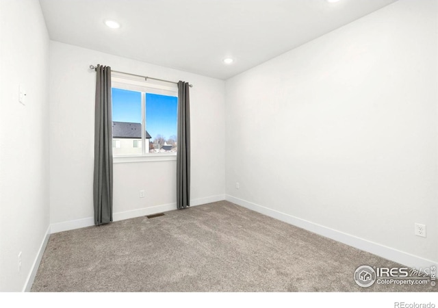 carpeted empty room featuring recessed lighting, visible vents, and baseboards