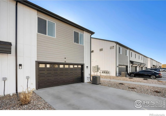 view of property exterior with concrete driveway, a garage, and board and batten siding