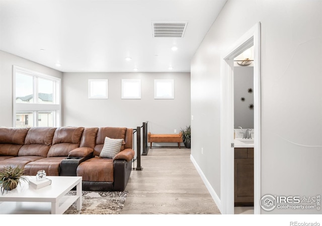 living area featuring light wood finished floors, recessed lighting, visible vents, and baseboards