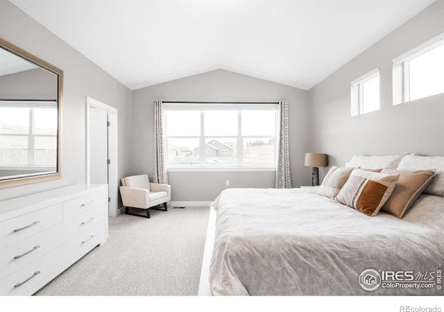 bedroom featuring lofted ceiling, baseboards, and light colored carpet