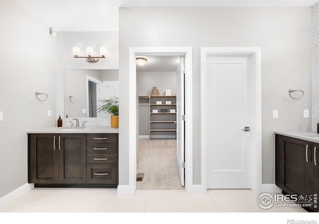 bathroom with tile patterned flooring, vanity, and baseboards