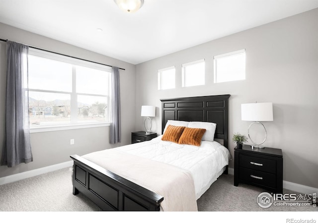 bedroom featuring light carpet and baseboards