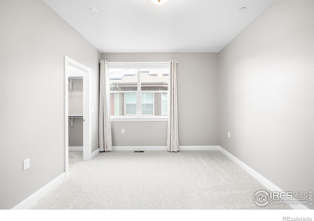 carpeted spare room featuring baseboards