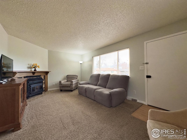 living room featuring carpet, baseboards, and a textured ceiling