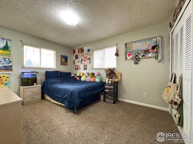 bedroom featuring a textured ceiling, a closet, baseboards, and light colored carpet