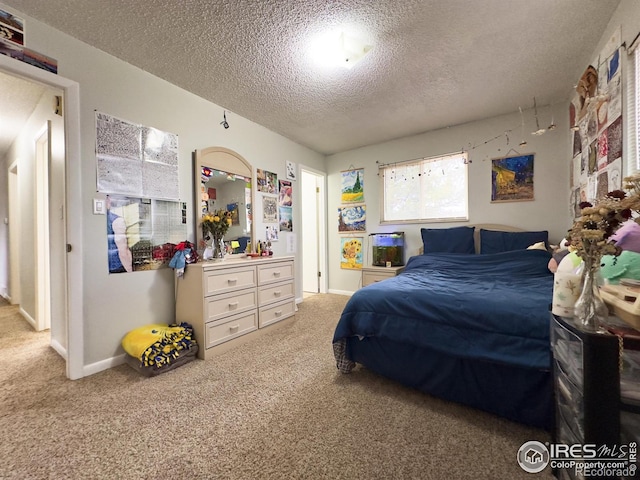 carpeted bedroom with a textured ceiling and baseboards