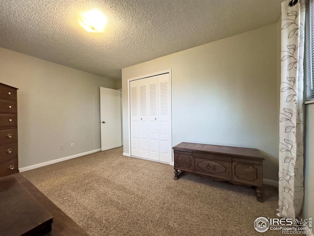 carpeted bedroom with a textured ceiling, baseboards, and a closet