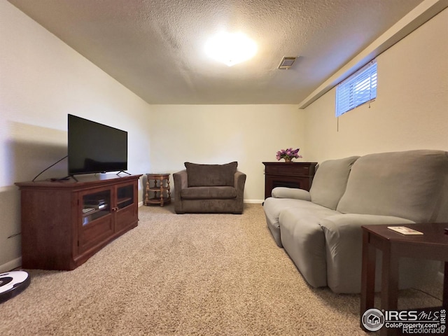 living area featuring carpet floors, visible vents, a textured ceiling, and baseboards