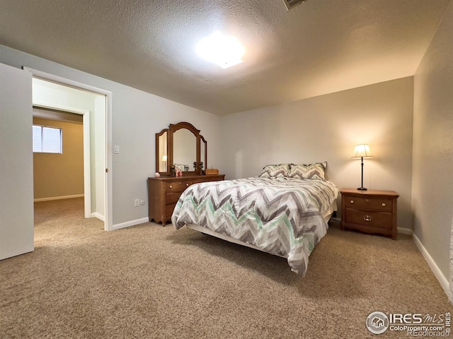 bedroom with carpet floors, baseboards, and a textured ceiling