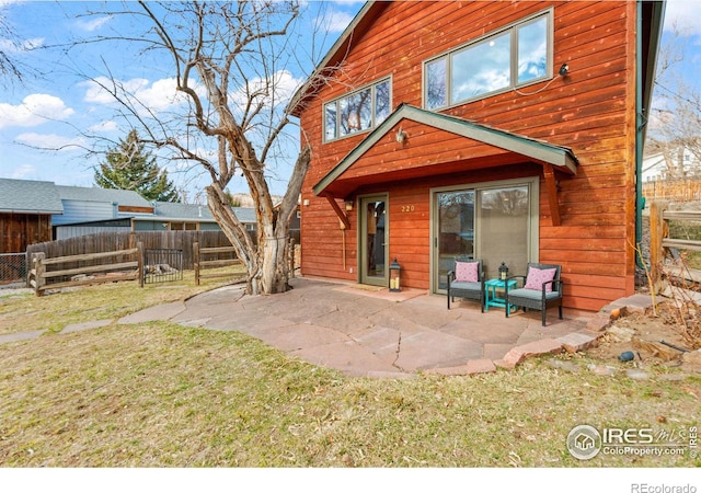 rear view of property with a lawn, a patio area, and fence