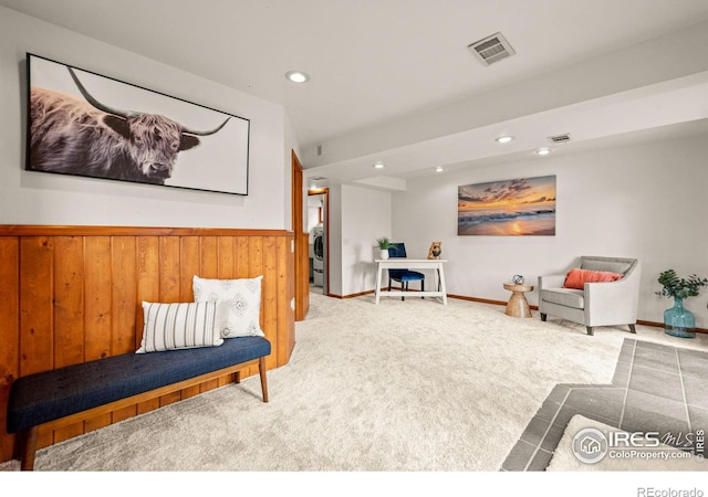 sitting room with carpet floors, recessed lighting, visible vents, wainscoting, and wood walls