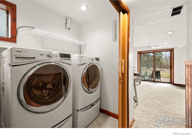 clothes washing area with laundry area, visible vents, baseboards, carpet flooring, and washing machine and dryer