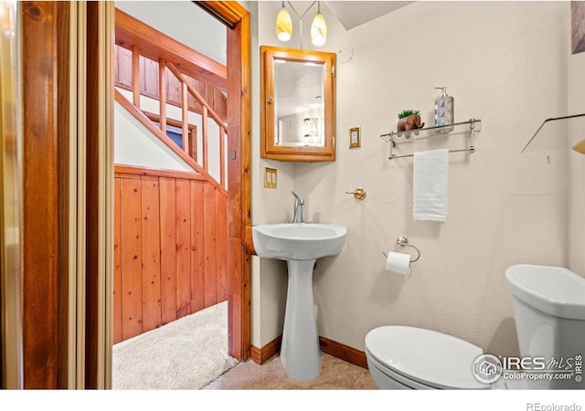 bathroom with baseboards and toilet