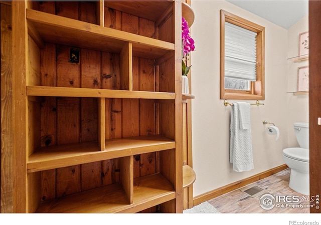 bathroom featuring toilet, baseboards, and wood finished floors