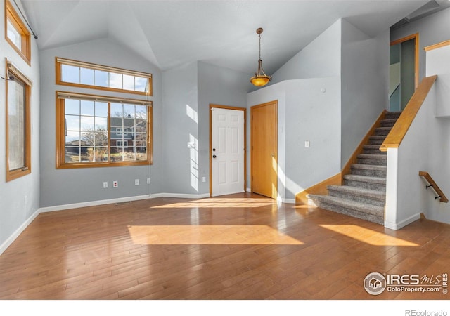 entrance foyer featuring high vaulted ceiling, stairway, wood-type flooring, and baseboards