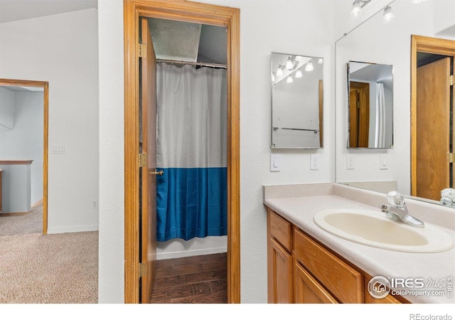 bathroom featuring curtained shower, baseboards, and vanity