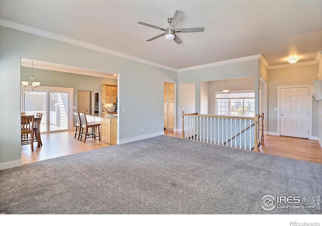 spare room featuring crown molding, baseboards, a wealth of natural light, and light colored carpet