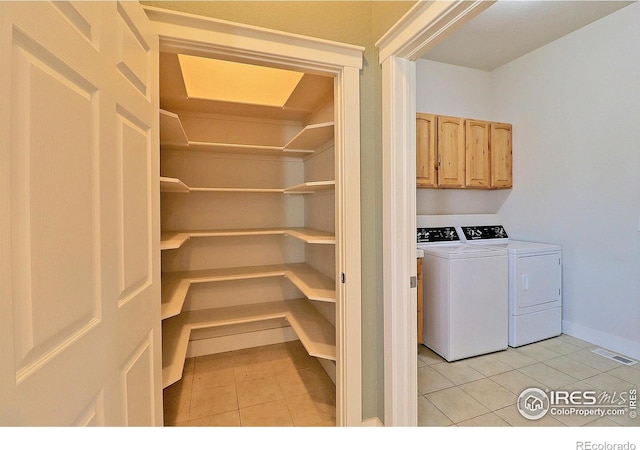 laundry area with cabinet space, visible vents, baseboards, independent washer and dryer, and light tile patterned flooring