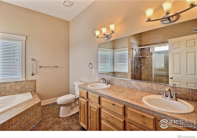 bathroom with double vanity, a shower stall, a sink, and tile patterned floors