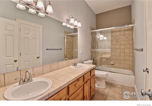 full bath with double vanity, tile patterned flooring, a sink, and toilet