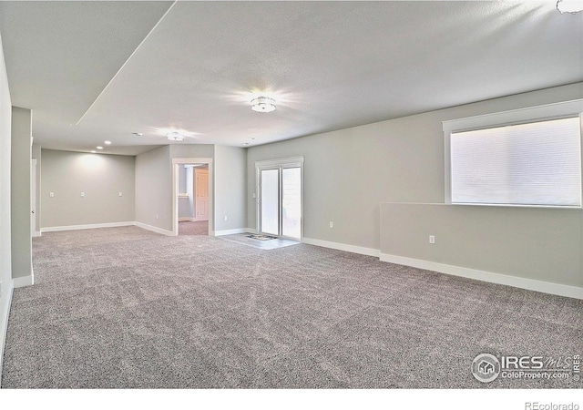 unfurnished room with carpet floors and baseboards