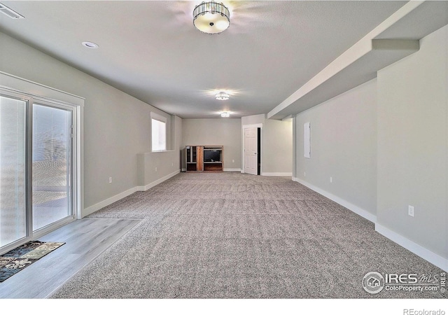 unfurnished living room featuring carpet floors, visible vents, and baseboards