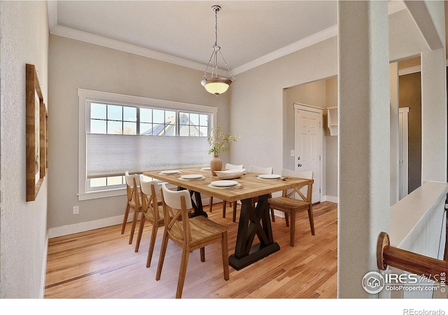 dining space with light wood-style floors, a wealth of natural light, and crown molding