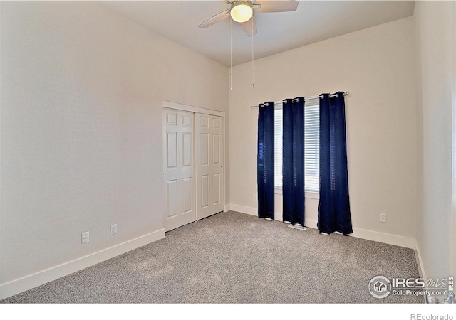 carpeted empty room featuring baseboards and a ceiling fan