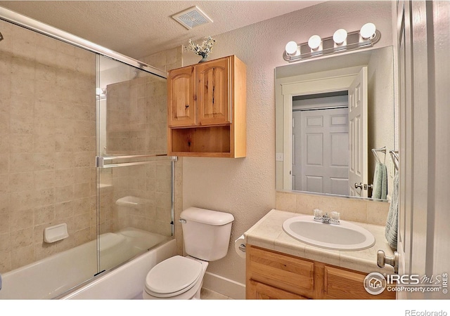 bathroom with visible vents, a textured wall, toilet, a textured ceiling, and vanity