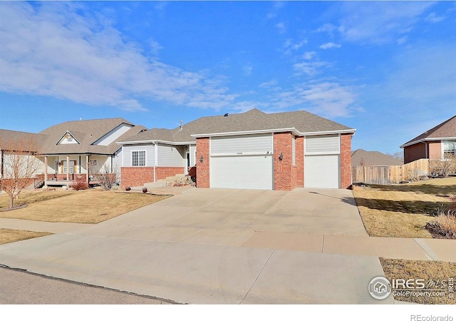 view of front of home with a garage, concrete driveway, brick siding, and fence