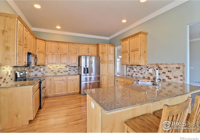 kitchen with stainless steel appliances, stone countertops, a peninsula, and a sink